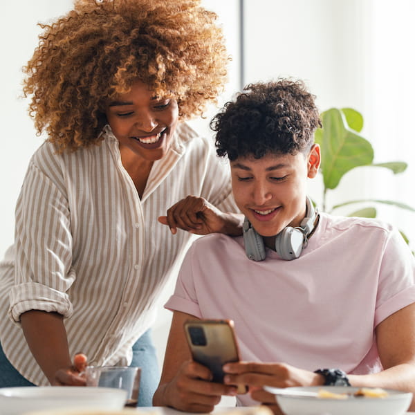 Woman and teenager looking at smartphone.