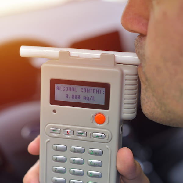 Person blowing into a breathalyzer